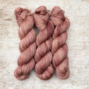Three skeins of merino and linen in a crushed raspberry pink