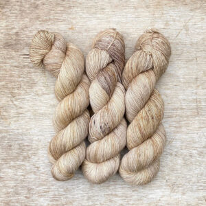 Three skeins of merino and linen in buttercream, coffee and gold