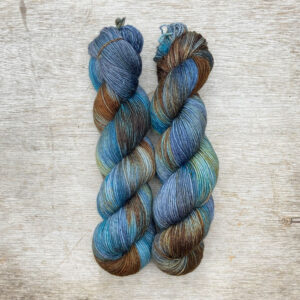 Two skeins of merino and mohair sock yarn in golden brown, denim and turquoise