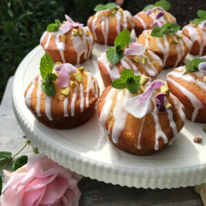 A cake stand with fairy cakes decorated with rose petals