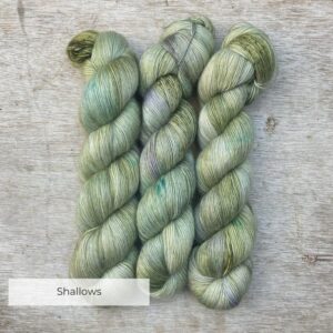 Three skeins of Merino Floof in pale green with splashes of moss and blue