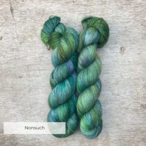 Two skeins of Merino Floof in pale green with splashes of moss , turquoise, gold and indigo