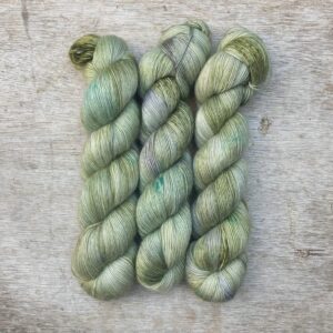 Three skeins of Merino Floof in pale green with splashes of moss and blue