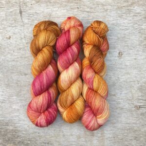 Three skeins of Classic Sock in mustard and raspberry pink