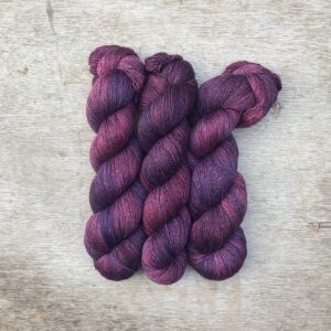 Three skeins of Merino & Silk in purple and plum