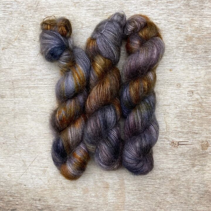 Three skeins of grey, orange and blue mohair and silk lace