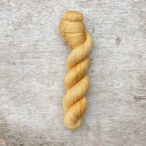 A single skein of linen sock in a soft golden yellow