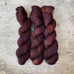Three skeins of merino and silk lace in brown, dusty pink and bronze