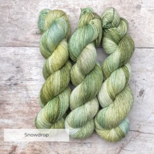 Three skeins of Merino & Silk in shades of green and moss