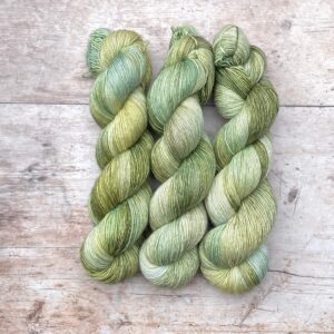 Three skeins of Merino & Silk in shades of green and moss