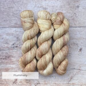 Three skeins of Merino & Silk single in the softest buttercream with splashes of cafe au lait