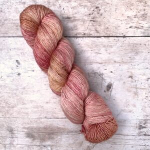Mid pink merino & silk yarn on a cream base with darker speckles