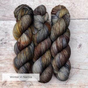 Three skeins of classic sock in dark blues, plum and gold