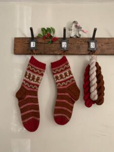 A pair of I'm a gingerbread man socks and yarn hanging from hooks