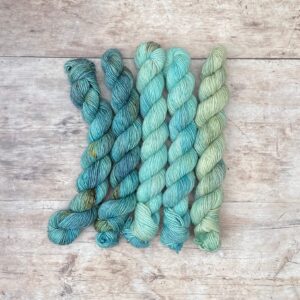 Five mini skeins of Flax in shades of blue and light aqua .