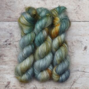 Three skeins of Mohair Lace in watery shades of blue and green with splashes of golden yellow