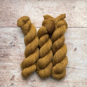 Three skeins of Flax a wool and linen blended yarn in a golden mustard
