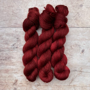 Three skeins of Merino Floof in a deep blood red