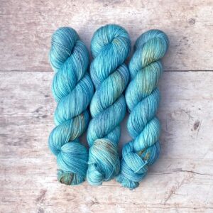 Three skeins of mohair sock in bright, sky blue with chocolate and gold speckles