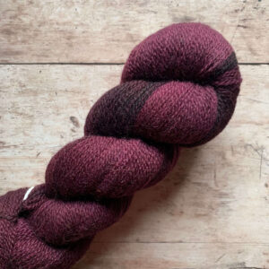 Three skeins of 4ply wool in deep plum purple