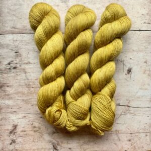 Three skeins of Merino Floof in soft yellow.
