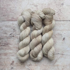 Three skeins Merino Silk in shades of cream and buff