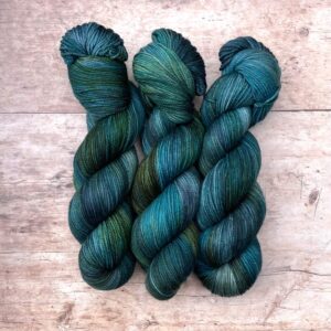 Three skeins pf Plump Sock in dark blues, emeralds and lime