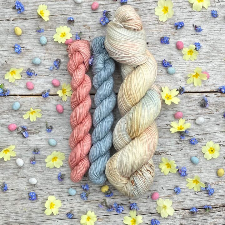 A full skein of Classic Sock in pastel cream, pink and blue with toffee coloured speckles with a small skeins of coordinating pink and blue