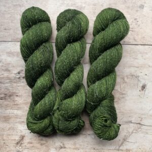 Three skeins of Merino and linen yarn in a deep vibrant green
