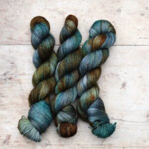 skeins of merino floof yarn in golden brown, denim and turquoise
