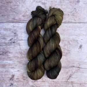 Two skeins of Classic Sock in shades of moss green, brown and pine
